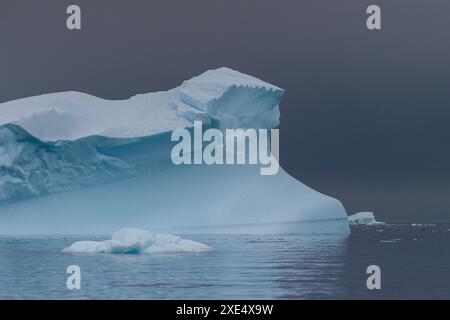 Un paesaggio antartico girato vicino all'isola di Cuverville, evidenziando montagne e iceberg. Foto Stock