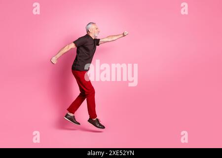 Foto del profilo laterale a grandezza naturale di una maglietta marrone vestita da uomo divertente che sembra un pugno a schiena con chiusura volante, spazio vuoto isolato su sfondo di colore rosa Foto Stock