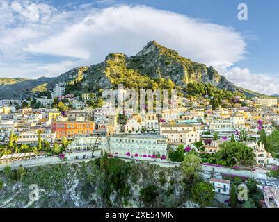 Paesaggio con Taormina, Sicilia, che mostra il pittoresco villaggio collinare e il paesaggio mediterraneo. Foto Stock