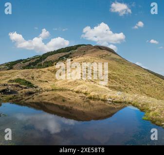 Piccolo e pittoresco lago con le nuvole che si riflettono sul Monte Strymba. Bella giornata autunnale nei Monti Carpazi vicino a Kolochav Foto Stock