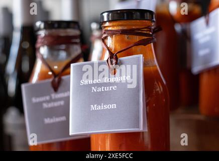 Salsa passata di pomodoro fatta in casa in bottiglie marcate in vetro trasparente, in vendita in un negozio nella Valle della Loira nel sud della Francia. Foto Stock