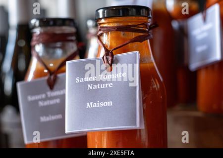 Salsa passata di pomodoro fatta in casa in bottiglie marcate in vetro trasparente, in vendita in un negozio nella Valle della Loira nel sud della Francia. Foto Stock
