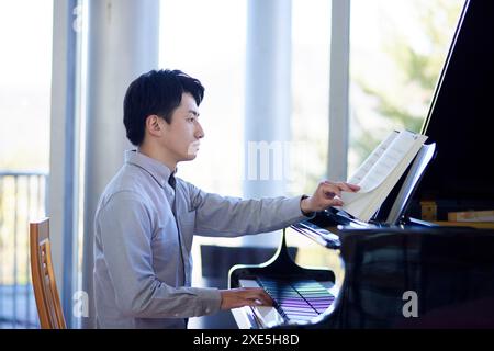 Uomo giapponese che suona il piano Foto Stock