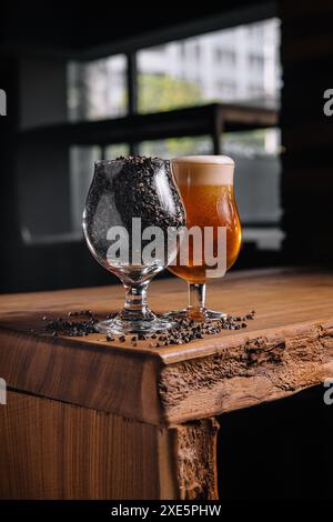 Bicchiere di birra e frumento in bicchiere su un tavolo di legno Foto Stock