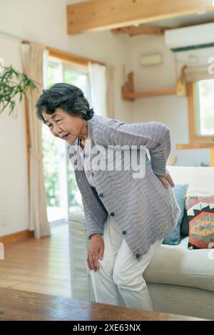 Donna anziana che soffre di mal di schiena Foto Stock
