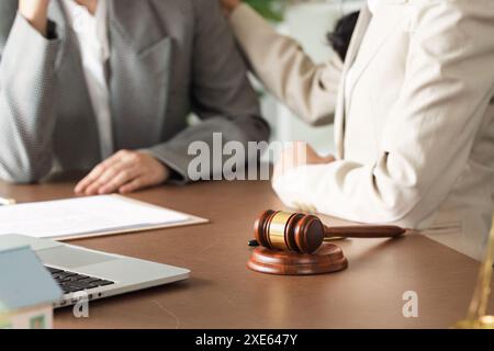 Avvocati professionisti che discutono questioni legali in ufficio con martelletto e documenti alla scrivania Foto Stock