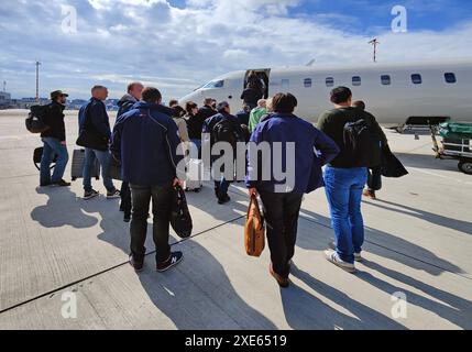 Passeggeri con bagaglio a mano a bordo di un piccolo aereo sull'asfalto, aeroporto, Duesseldorf, Germania Foto Stock