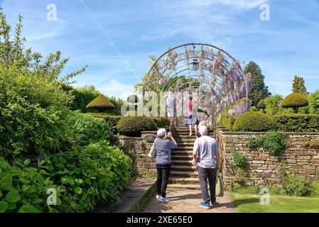 Visitatori che si godono una prima giornata di sole nelle prime estati presso il RHS, i giardini della Royal Horticultural Society a Wisley Surrey, Inghilterra, Regno Unito Foto Stock