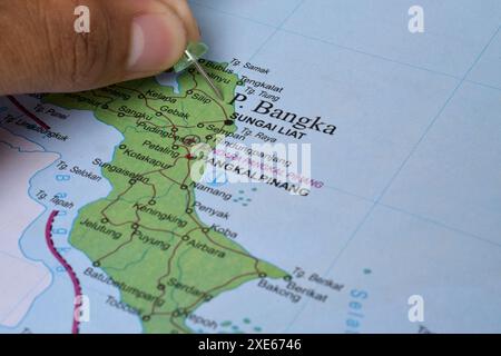 Il dito che punta sulla Mappa dell'Isola di Bangka, è una piccola isola situata proprio sulla punta nord-orientale di Sulawesi, Indonesia Foto Stock