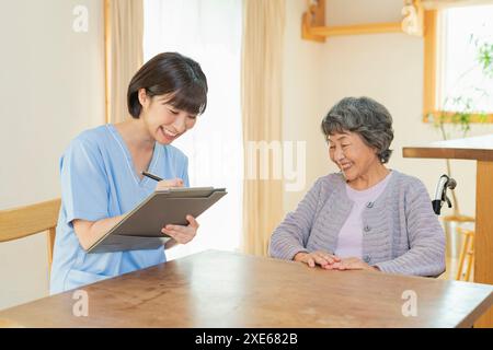 Operatore sanitario femminile che ascolta un utente Foto Stock