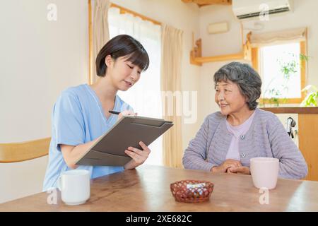 Operatore sanitario femminile che ascolta un utente Foto Stock