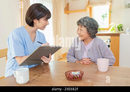 Operatore sanitario femminile che ascolta un utente Foto Stock