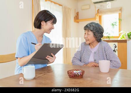 Operatore sanitario femminile che ascolta un utente Foto Stock