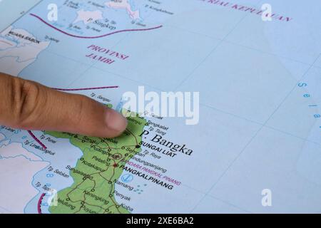 Il dito che punta sulla Mappa dell'Isola di Bangka, è una piccola isola situata proprio sulla punta nord-orientale di Sulawesi, Indonesia Foto Stock