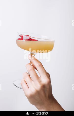 Mano di donna che tiene un cocktail daiquiri con fragole Foto Stock