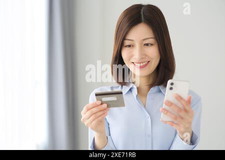 Donna con smartphone e carta di credito Foto Stock
