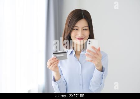 Donna con smartphone e carta di credito Foto Stock