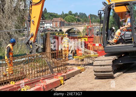 Bewdley, Regno Unito. 26 giugno 2024. Meteo nel Regno Unito: I lavoratori edili che installano le principali difese alluvionali di Bewdley sono fuori sotto il sole di mezzogiorno. Con temperature che raggiungono i 27 gradi, i lavoratori si innestano duramente al sole estivo, adattando ironicamente le difese contro le inondazioni in uno dei giorni più caldi e secchi dell'anno. Crediti: Lee Hudson/Alamy Live News Foto Stock