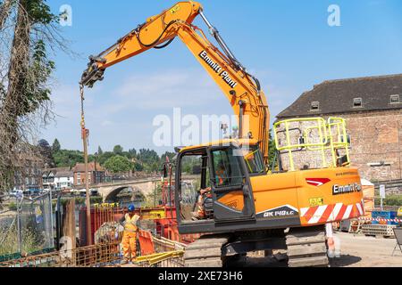 Bewdley, Regno Unito. 26 giugno 2024. Meteo nel Regno Unito: I lavoratori edili che installano le principali difese alluvionali di Bewdley sono fuori sotto il sole di mezzogiorno. Con temperature che raggiungono i 27 gradi, i lavoratori si innestano duramente al sole estivo, adattando ironicamente le difese contro le inondazioni in uno dei giorni più caldi e secchi dell'anno. Crediti: Lee Hudson/Alamy Live News Foto Stock