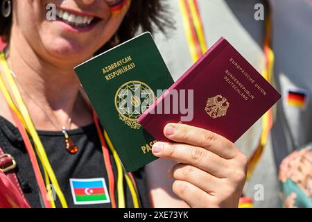 26 giugno 2024, Berlino: Le persone mostrano i loro due passaporti, il passaporto tedesco e il passaporto azero, durante una sessione fotografica a sostegno della nuova legge sulla cittadinanza. La legge sulla modernizzazione della legge sulla cittadinanza entra in vigore il 27 giugno 2024. Foto: Jens Kalaene/dpa Foto Stock