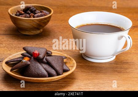 Vista dei deliziosi cracker di brownie alla frutta secca e croccanti fatti in casa in un piatto di legno. Foto Stock