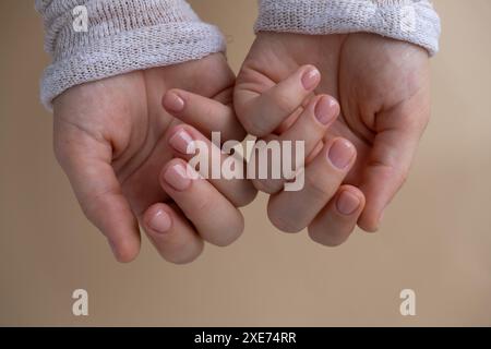 Unghie pastello morbide e curate su sfondo beige neutro. Donna che mostra la sua nuova manicure nei colori della tavolozza pastello. Semplice Foto Stock