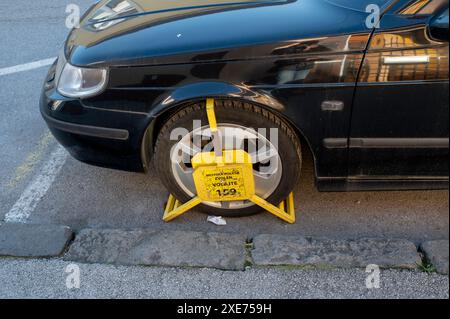 Zvolen, Slovacchia - 26 novembre 2023: Una ruota anteriore bloccata dal blocco ruote per parcheggi illegali o non autorizzati. Un cla ruota Foto Stock