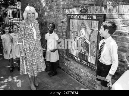 NOTA DELL'EDITOR l'immagine è stata convertita in bianco e nero. La regina Camilla ammira un murale in ceramica che celebra l'incoronazione di re Carlo III nel giardino della scuola, durante la sua visita alla Christ Church C of e Primary School di Londra, per celebrare il loro Festival letterario. Data foto: Mercoledì 26 giugno 2024. Foto Stock