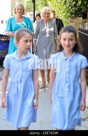 La regina Camilla è guidata dagli alunni Lexi (a sinistra), di otto anni, e Marina, di nove anni durante la sua visita alla Christ Church C of e Primary School di Londra, per celebrare il loro Festival letterario. Data foto: Mercoledì 26 giugno 2024. Foto Stock