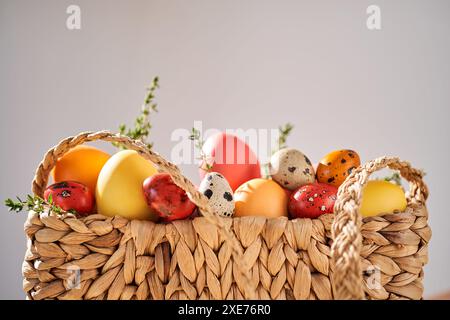 Uova di Pasqua in un sacchetto di vimini. Composizione pasquale. Foto Stock