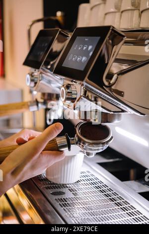 Barista fa caffè in una macchina per il caffè Foto Stock