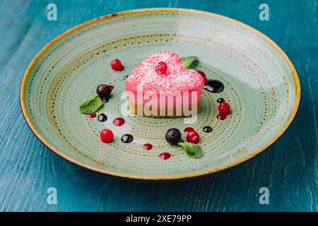 Torta rossa vegana cruda a forma di cuore con lamponi Foto Stock