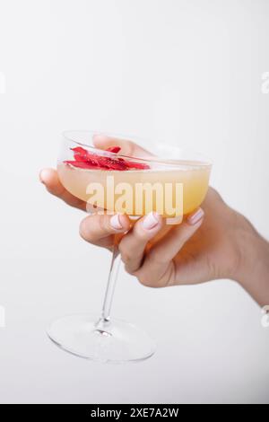 Mano di donna che tiene un cocktail daiquiri con fragole Foto Stock