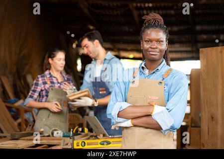 Ritratto della lavoratrice lavoratrice di falegnameria in piedi di fronte a una collega in officina Foto Stock