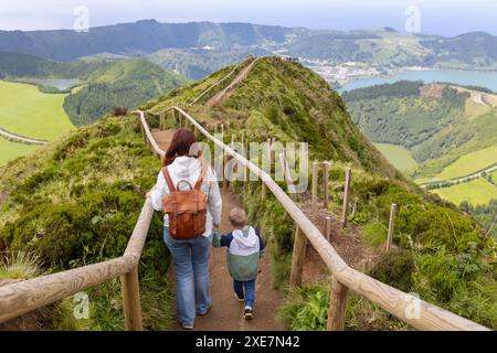 Una donna e un bambino camminano su un sentiero in una zona verde lussureggiante Foto Stock