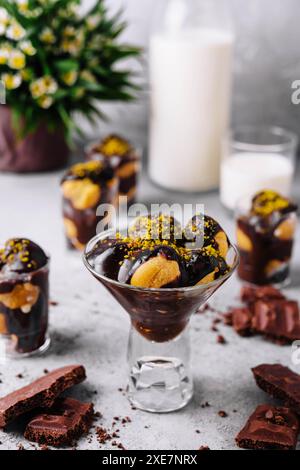 Cucina francese, gustosi profiteroles di dessert con cioccolata calda Foto Stock