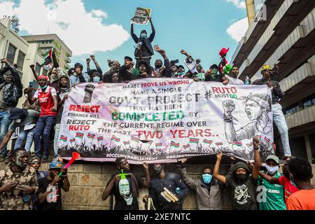 Nairobi, Kenya. 25 giugno 2024. I manifestanti tengono uno striscione e gridano slogan, durante la manifestazione. I giovani manifestanti si sono organizzati sotto la bandiera di "Occupy Parliament", coraggiosi gas lacrimogeni, cannoni ad acqua e una pesante presenza della polizia mentre marciavano per le strade della città, cantando e chiedendo ai loro leader di respingere il disegno di legge. La polizia del Kenya ha bloccato le strade che portano al parlamento e alla State House per fermare le proteste guidate dai giovani contro gli aumenti fiscali proposti nel disegno di legge finanziario del Kenya 2024/2025. Credito: SOPA Images Limited/Alamy Live News Foto Stock