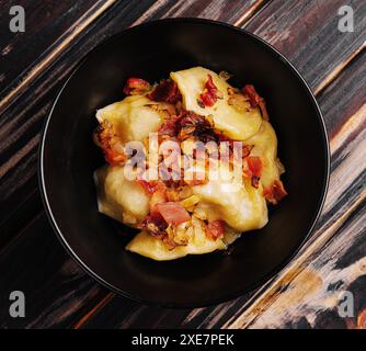 Gnocchi di patate al forno con pancetta fritta e cipolle Foto Stock