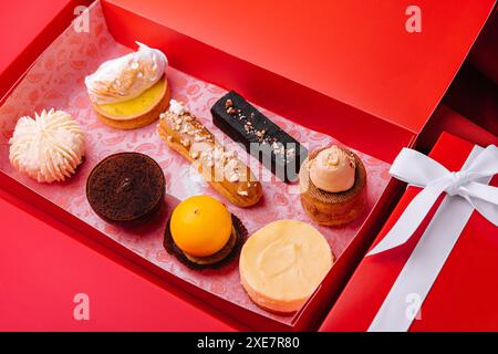 Regali di Natale con torte diverse su sfondo rosso Foto Stock