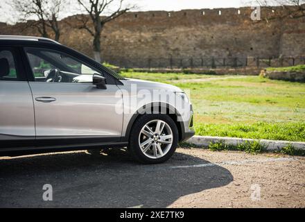 Parte anteriore del SEGGIOLINO per auto crossover Arona in argento compatto. Mura del vecchio castello - fortezza di Akkerman - sullo sfondo. Foto Stock