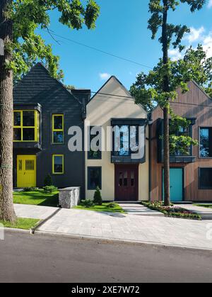 Case colorate affiancate. Strada con piccole case moderne in una giornata di sole. Nuovo quartiere nell'area suburbana. Foto Stock