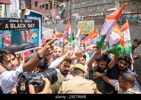 Srinagar, India. 26 giugno 2024. I poliziotti indiani fermano i lavoratori del partito del Congresso Nazionale della Gioventù indiana del Kashmir e Jammu mentre protestano contro una presunta truffa negli esami medici nazionali NEET, che sono tenuti dalla National Testing Agency (NTA). Protestano contro le irregolarità del governo e le fughe di carta, insieme a un forte aumento della lista dei meriti del prestigioso esame, in cui 67 studenti senza precedenti stanno segnando il 100% nella storia dell'agenzia di test. Credito: SOPA Images Limited/Alamy Live News Foto Stock