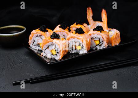 Sushi roll con salmone fritto, gamberi e caviale nero Foto Stock