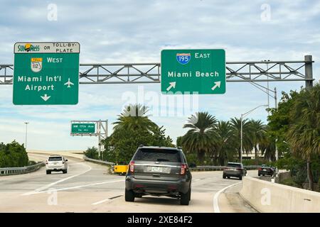 Miami, Florida, Stati Uniti - 5 dicembre 2023: Cartelli direzionali su un'autostrada della città che mostrano le strade per l'aeroporto e Miami Beach Foto Stock