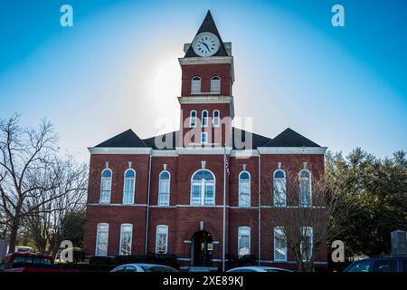 Jesup, Georgia, USA - 14 febbraio 2024: Lo storico tribunale della contea di Wayne, caratterizzato da un'importante torre dell'orologio e finestre ad arco, si trova in una pittoresca sma Foto Stock