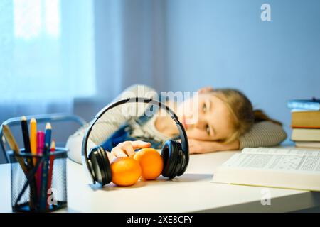 Studentessa adolescente sdraiata sulla scrivania con libri. giovane donna stanca che piange il suo libro di testo. Stanchezza, stanchezza, istruzione, preparazione Foto Stock