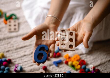 giovane donna che tiene in mano numeri di legno multicolore Foto Stock