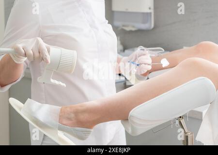 Ginecologo azienda specolo in clinica prima di esame paziente Foto Stock