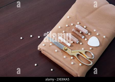 Gruppo di oggetti da cucire distesi su un tavolo di legno, concetto di sartoria Foto Stock