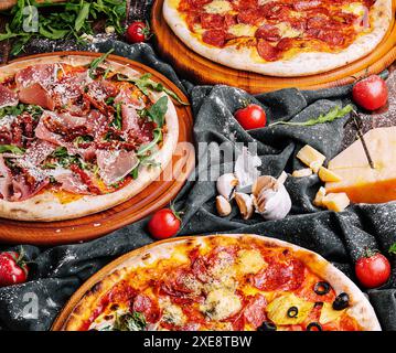 Gustose pizze assortite su tavole di legno Foto Stock